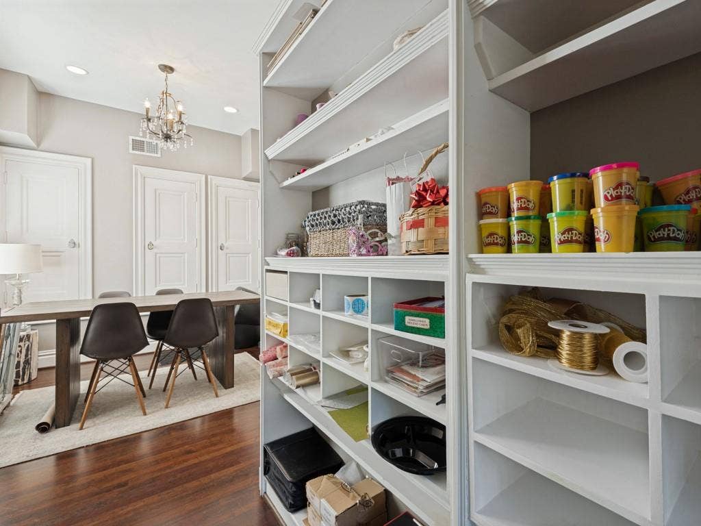6858 Tokalon Drive, Dallas, TX 75214 Custom floor-to-ceiling built-in cabinetry featuring extensive shelving and storage cubbies, paired with rich wood flooring, recessed lighting, and a traditional chandelier
