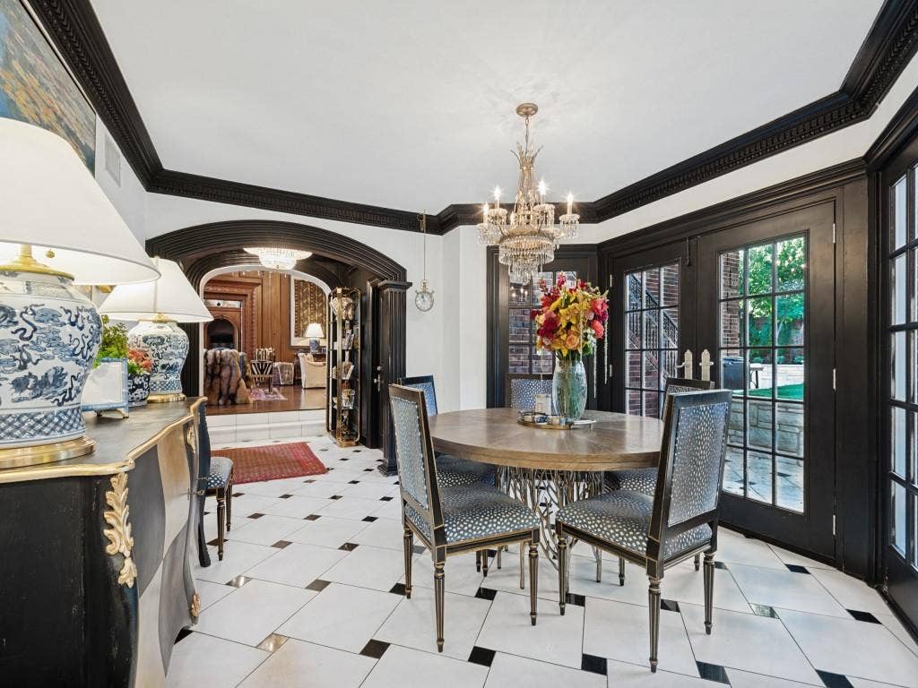 6858 Tokalon Drive, Dallas, TX 75214 Dining space featuring oversized white floor tiles with black accent squares, contrasting black crown molding, arched entryways, and double glass-paneled doors with black trim