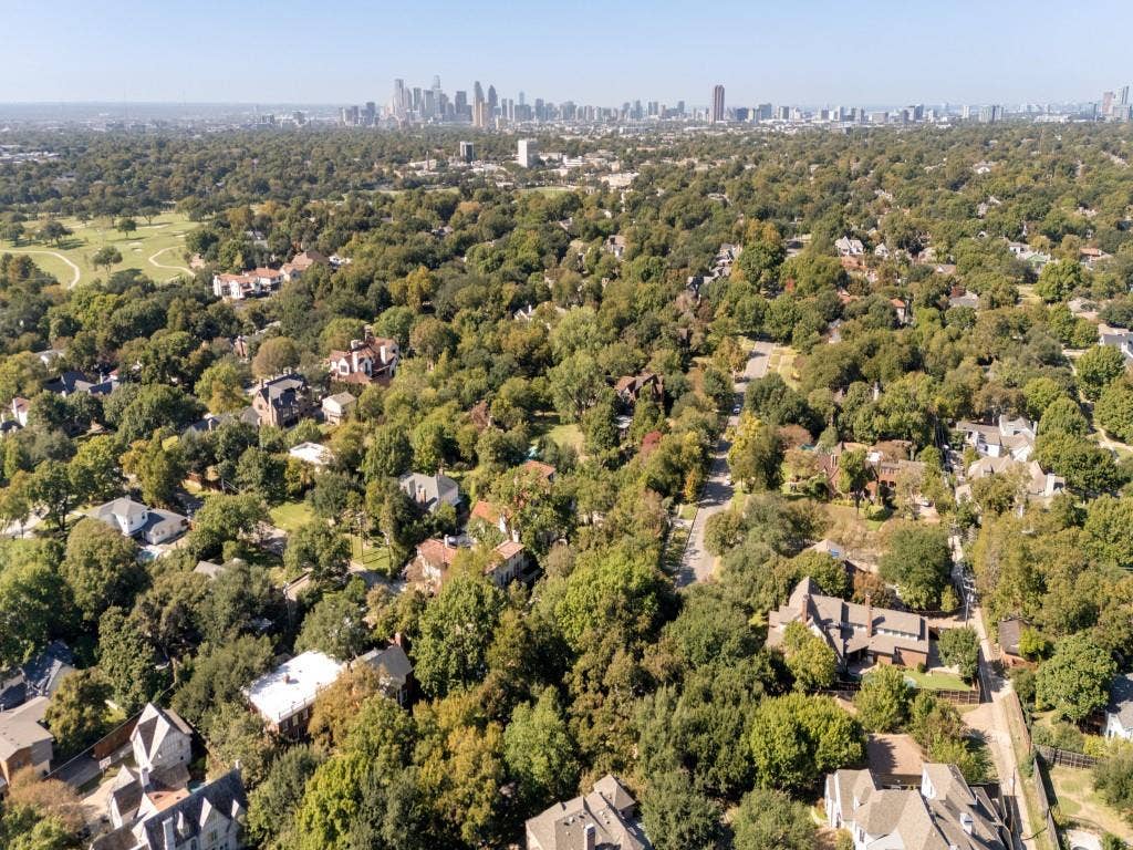 6858 Tokalon Drive, Dallas, TX 75214 Aerial perspective featuring a heavily wooded canopy and a skyline horizon