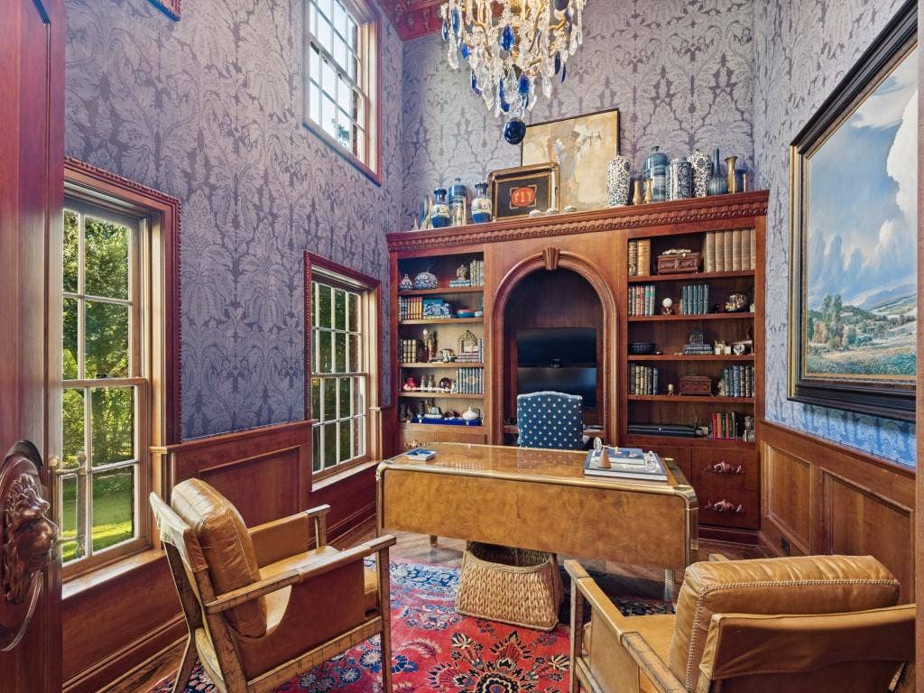 6858 Tokalon Drive, Dallas, TX 75214 Study featuring custom floor-to-ceiling wood cabinetry with an arched niche, damask patterned wall coverings, wood wainscoting, multi-pane windows, and a tiered crystal chandelier