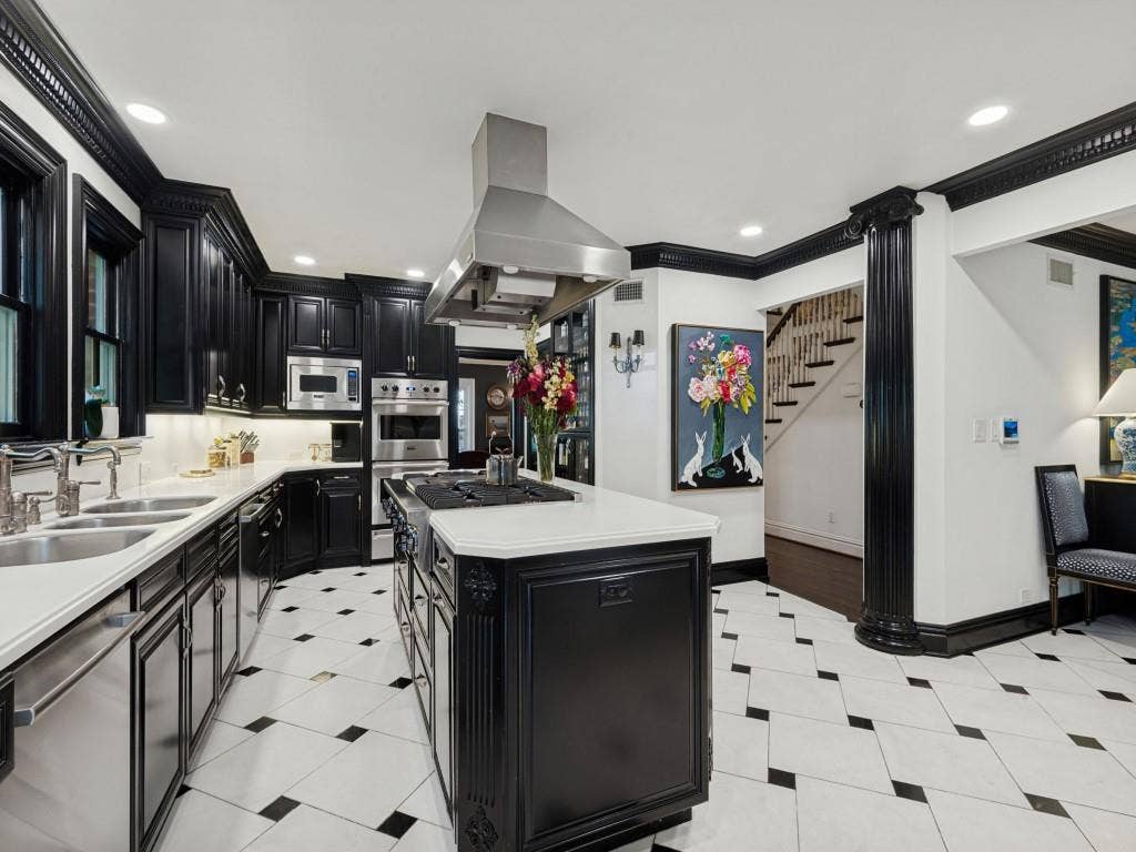 6858 Tokalon Drive, Dallas, TX 75214 Kitchen featuring custom black cabinetry, a central island with a gas cooktop, white solid-surface countertops, stainless steel range hood, and black-and-white diamond pattern tile flooring