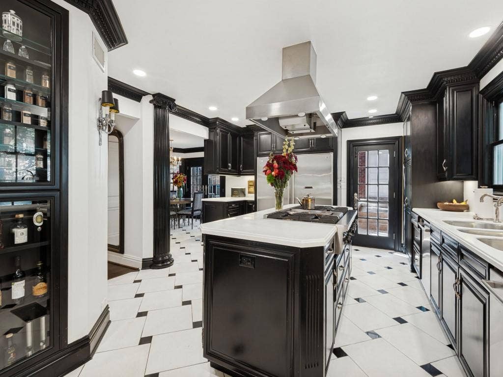 6858 Tokalon Drive, Dallas, TX 75214 Kitchen featuring custom black cabinetry, central island with gas cooktop, stainless steel ventilation hood, stone countertops, and geometric tile flooring