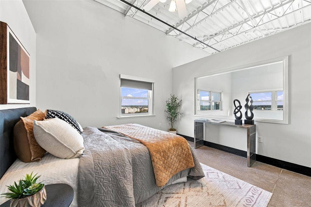 219 S 4th Street, #608, Waco, TX 76701 Exposed ceiling joists with white finish, dual windows with roller shades, built-in wall mirror, and modern console table