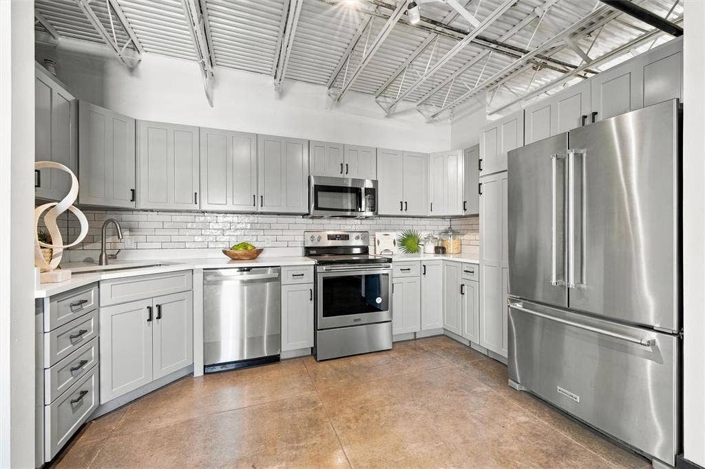 219 S 4th Street, #608, Waco, TX 76701 Kitchen featuring light gray cabinetry, stainless steel appliances, white subway tile backsplash, white countertops, and exposed ceiling trusses