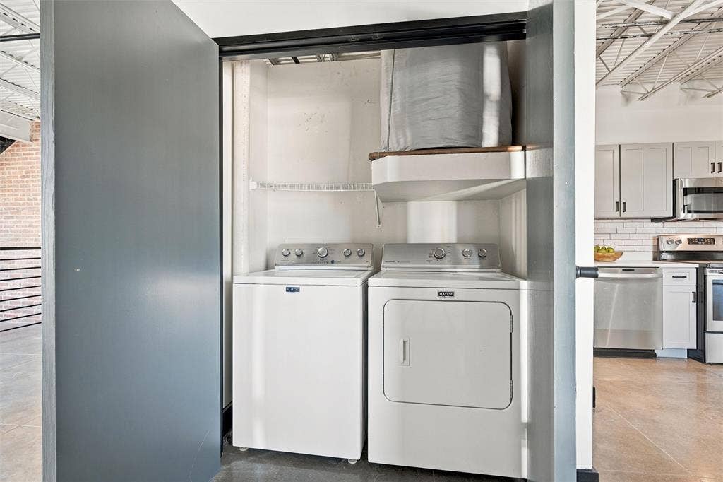 219 S 4th Street, #608, Waco, TX 76701 Laundry closet featuring a stackable washer and dryer, upper shelving, and a wood-finish shelf