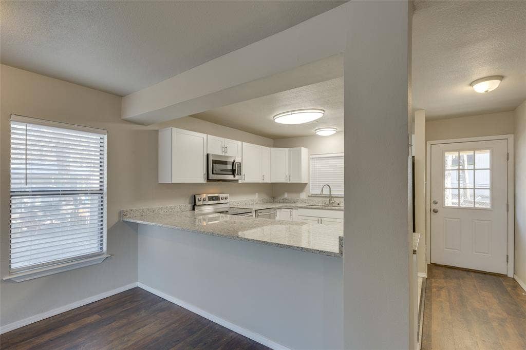 157 Harborr Drive, Gun Barrel City, TX 75156 Kitchen with granite countertops, white cabinets, dark wood-type flooring and breakfast bar