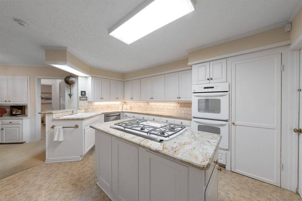 6950 Midcrest Drive, Dallas, TX 75254 Island with 5 burner gas cooktop and downdraft.