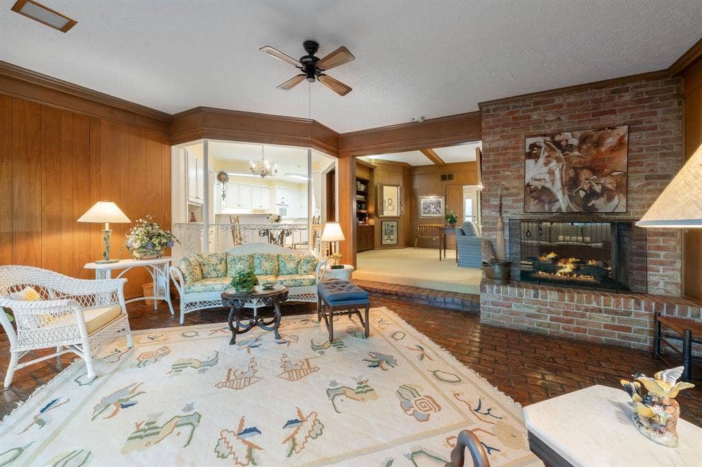 6950 Midcrest Drive, Dallas, TX 75254 Sun Room with See Through Fireplace from the Family Room and brick flooring.