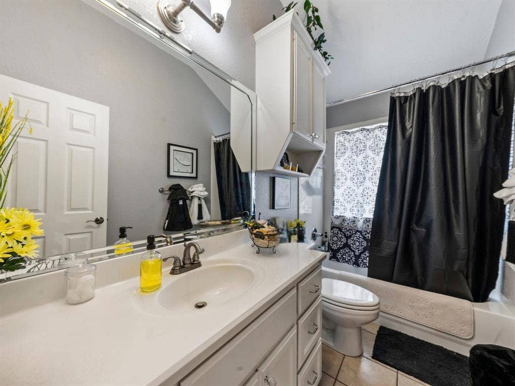 3012 Pinto Loop, Robinson, TX 76706 White vanity with integrated sink, brushed nickel faucet, large wall mirror, and overhead lighting
