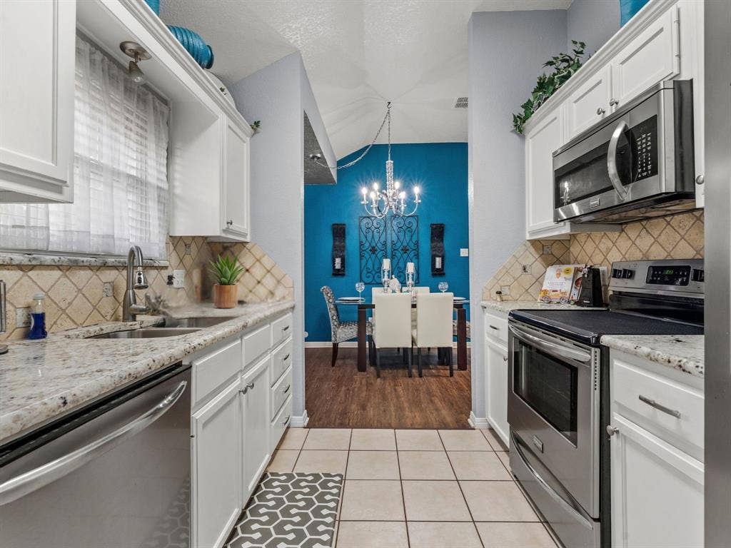 3012 Pinto Loop, Robinson, TX 76706 White cabinetry with brushed nickel hardware, speckled countertops, stainless steel appliances, and a tiled backsplash