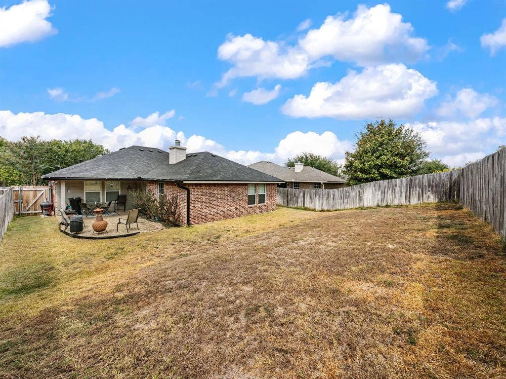 3012 Pinto Loop, Robinson, TX 76706 Brick exterior with a covered patio, a stone patio, and a wood privacy fence