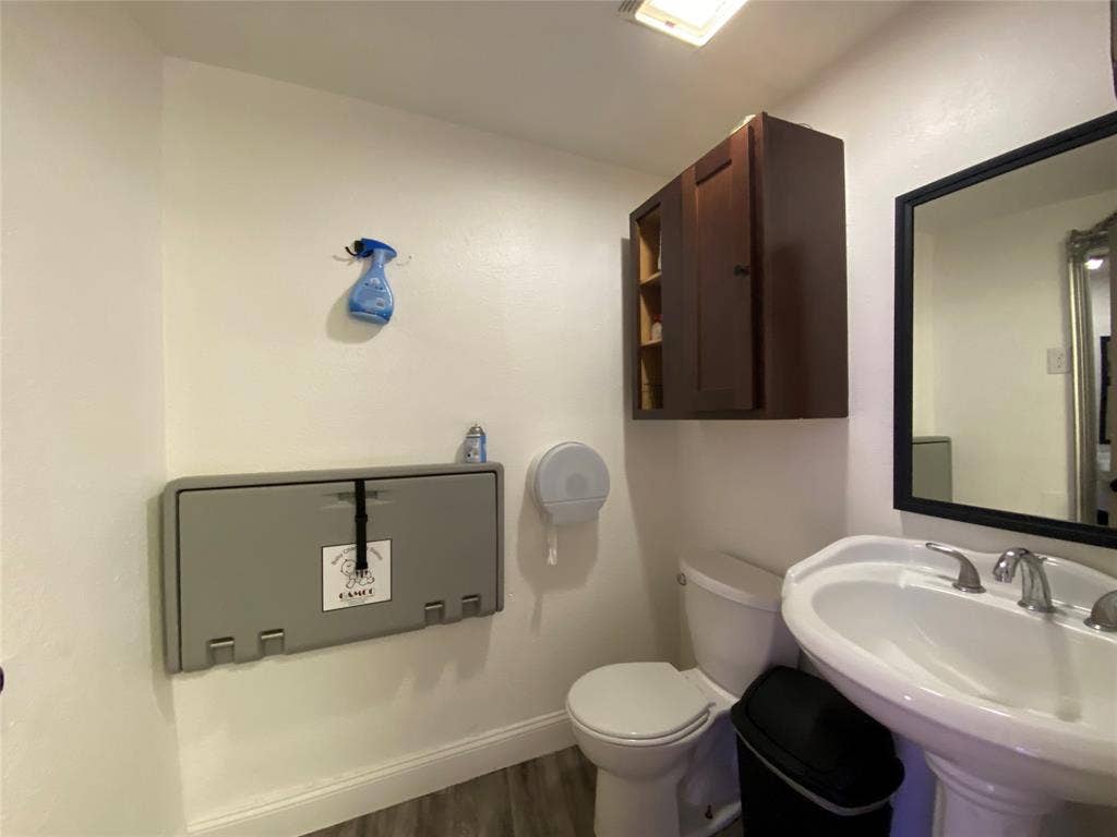 7041 Military Parkway, Dallas, TX 75227 Bathroom featuring wood-type flooring, toilet, and sink