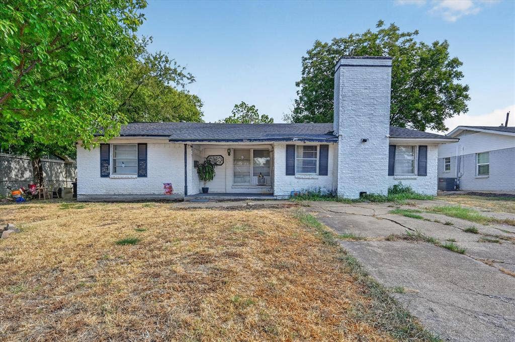 3320 Shorewood Drive, Mesquite, TX 75150 White brick facade with dark shutters, prominent brick chimney, and a covered front entry