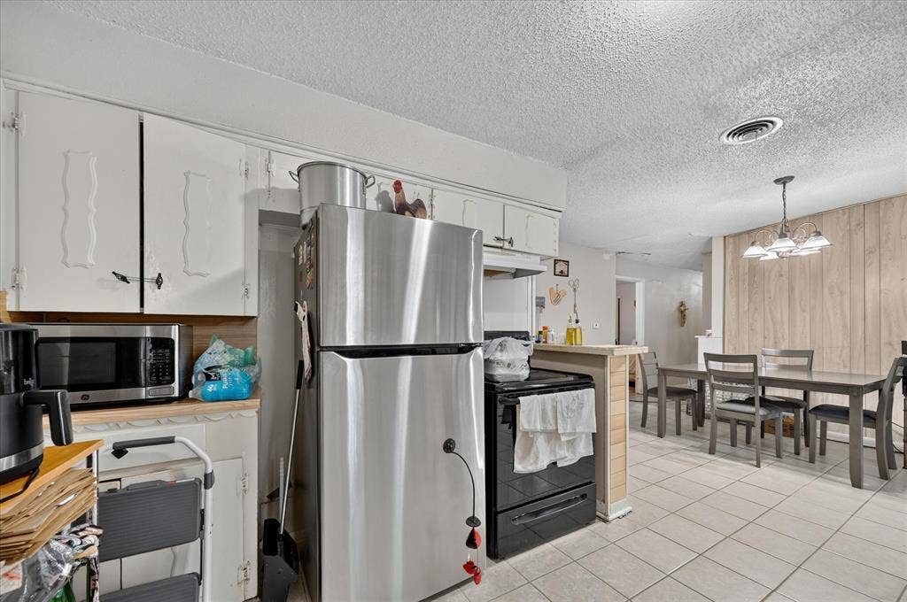 3320 Shorewood Drive, Mesquite, TX 75150 Kitchen featuring white cabinetry, stainless steel appliances, and tile flooring