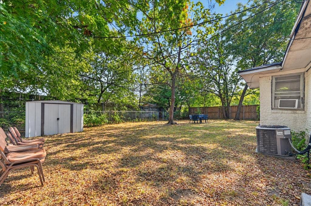 3320 Shorewood Drive, Mesquite, TX 75150 Expansive backyard featuring a mature tree, privacy fencing, and a metal storage shed