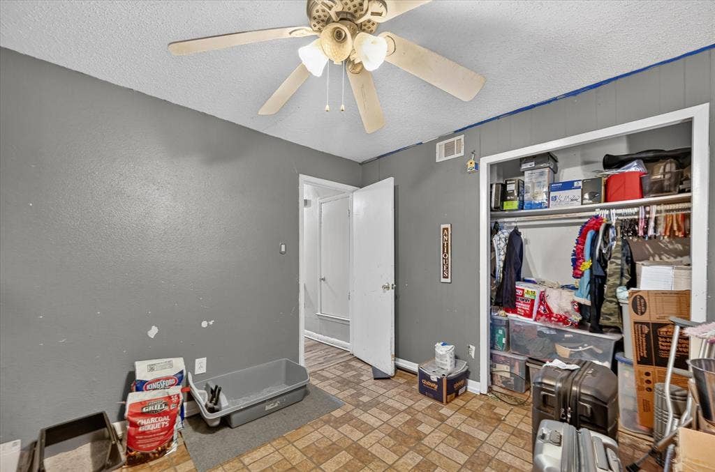 3320 Shorewood Drive, Mesquite, TX 75150 Built-in ceiling fan, textured ceiling, panel accent wall, and a built-in closet with shelving and hanging rod