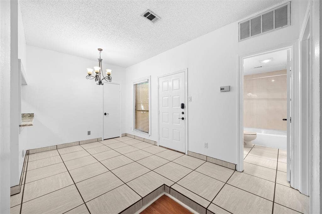 7340 Skillman Street, #909, Dallas, TX 75231 Recessed lighting, tile flooring, window with blinds, paneled interior door, and a built-in shelf with a stone-finish countertop