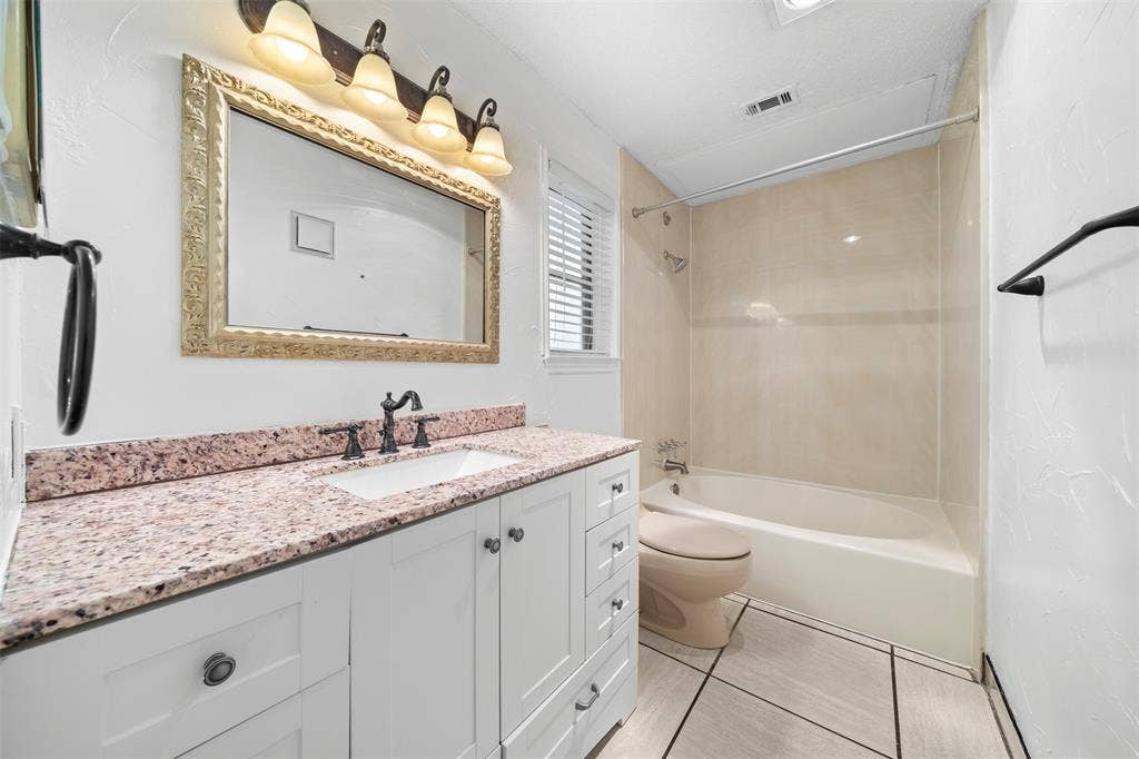 7340 Skillman Street, #909, Dallas, TX 75231 White shaker-style vanity with a speckled countertop, undermount sink, and dark-toned faucet