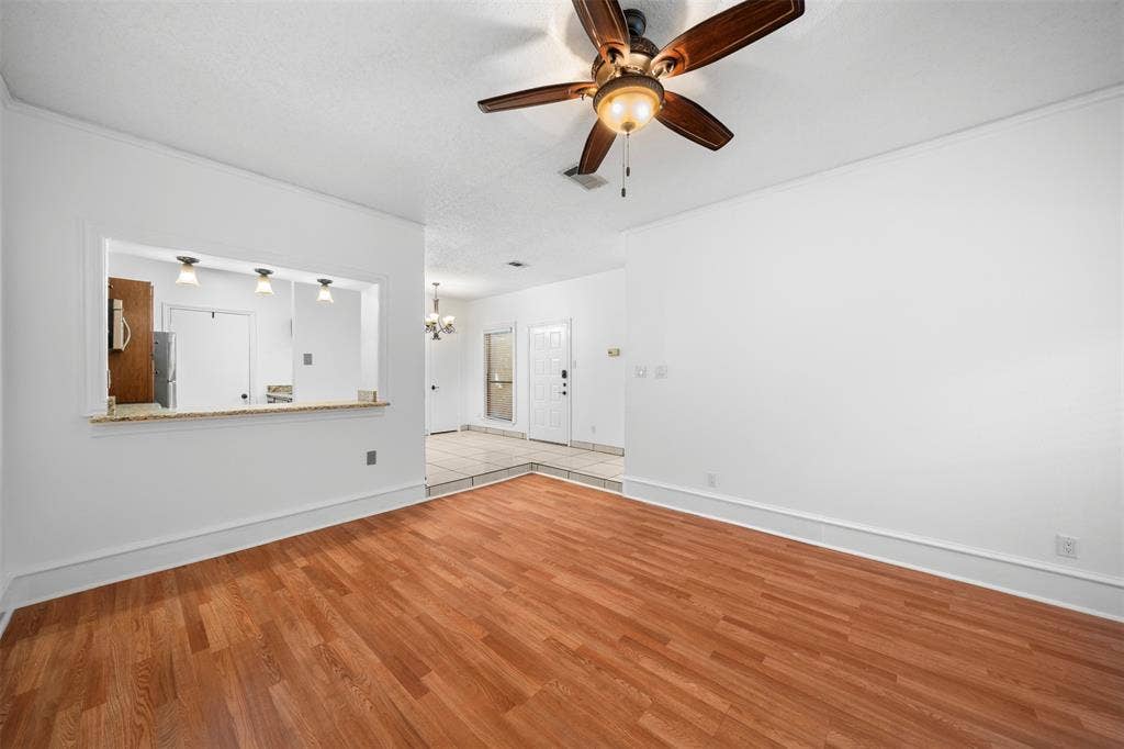7340 Skillman Street, #909, Dallas, TX 75231 Wood-finish flooring with a pass-through window to the kitchen