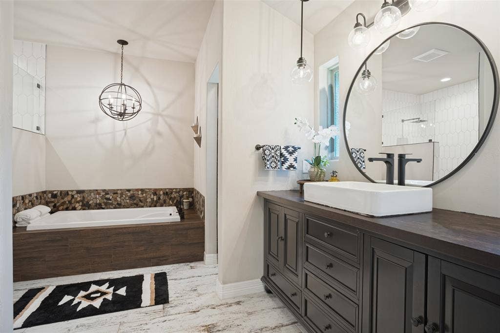 18 Brookhaven Drive, Lucas, TX 75002 Beautifully remodeled primary bath with decorative lighting, separate tub and shower and walk in closet.