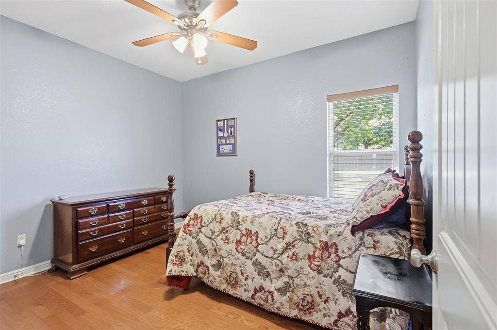 Wood-finish flooring with a ceiling fan and overhead lighting