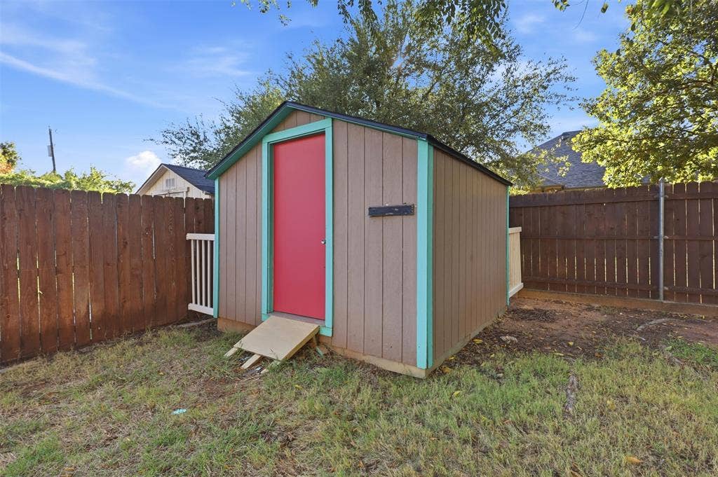 Storage shed with a pitched roof, wood siding, and contrasting trim