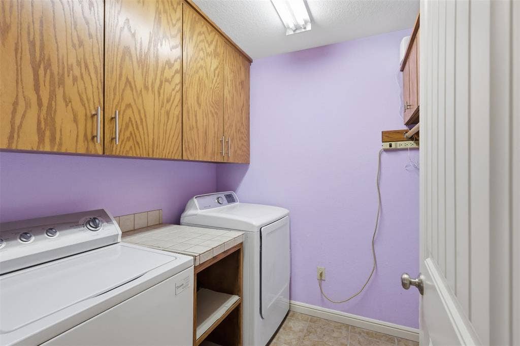 Built-in wood cabinetry with chrome hardware, tile countertop, and vinyl flooring