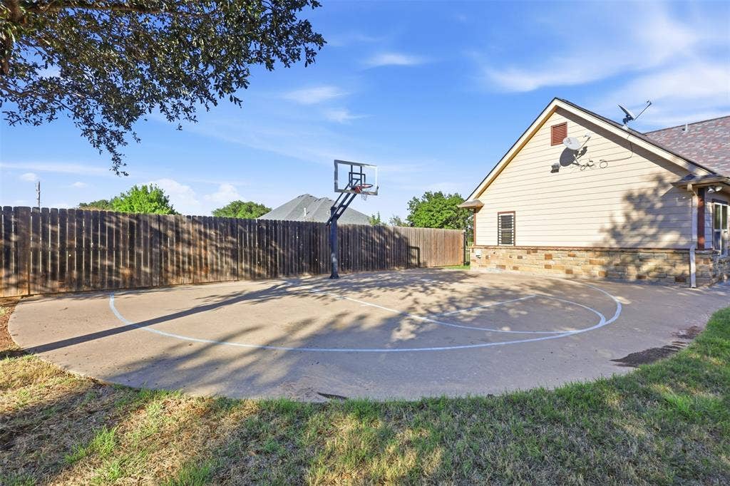 Concrete sport court with painted markings and an adjustable basketball hoop