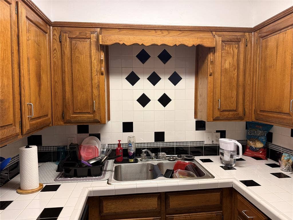 1915 S 10th Street, Waco, TX 76706 Wood-finish cabinetry complemented by a tile backsplash and tile countertops