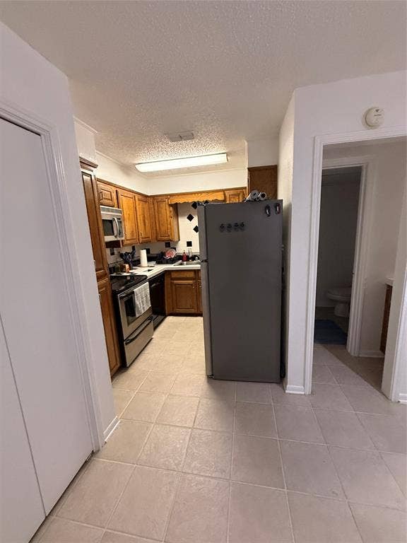 1915 S 10th Street, Waco, TX 76706 Kitchen featuring wood cabinetry, stainless steel appliances, and a tile backsplash