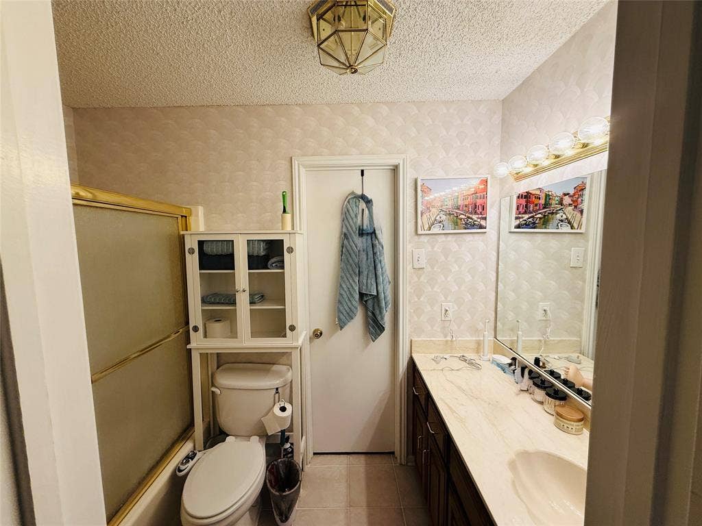 1915 S 10th Street, Waco, TX 76706 Vanity with an integrated sink, broad wall-mounted mirror, and a multi-bulb light fixture