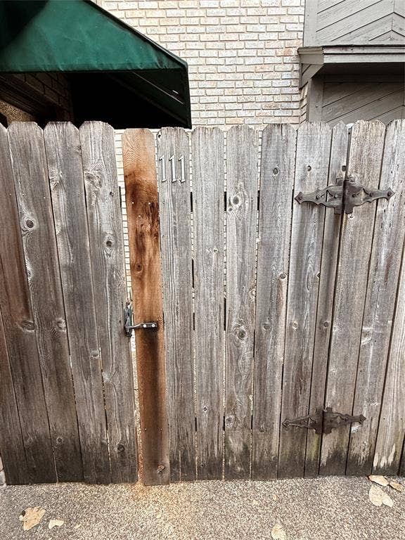 1915 S 10th Street, Waco, TX 76706 Wood privacy fence with decorative iron hardware, featuring a secure latch and prominent house numbers