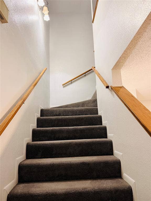 1915 S 10th Street, Waco, TX 76706 Carpeted staircase with wood handrails and overhead lighting fixture