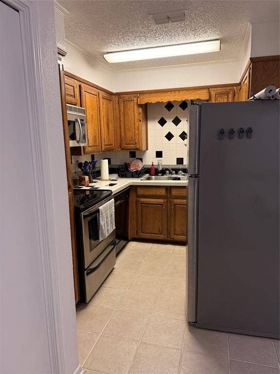 1915 S 10th Street, Waco, TX 76706 Kitchen with wood cabinetry, stainless steel appliances, and tiled flooring