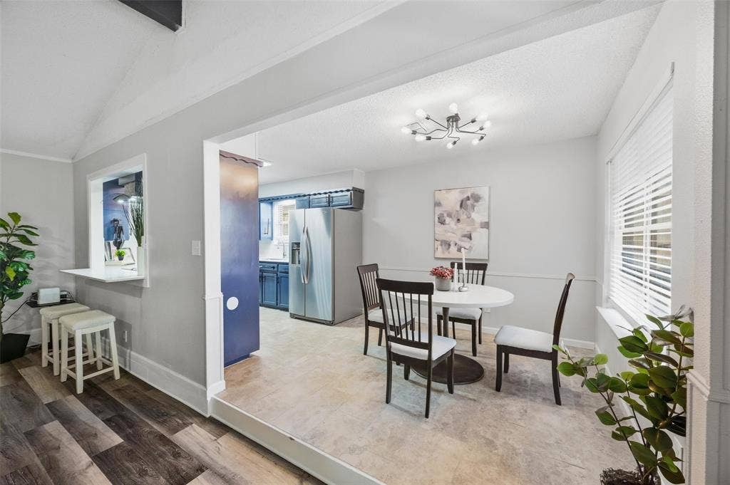 Wood-finish flooring, pass-through window with counter seating, recessed entryway, contemporary light fixture, and horizontal blinds