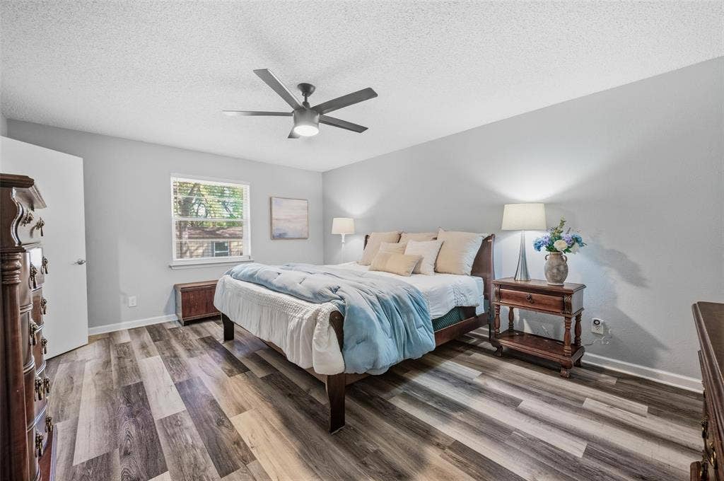 Wood-finish flooring, ceiling fan, window with natural light, and light-toned walls
