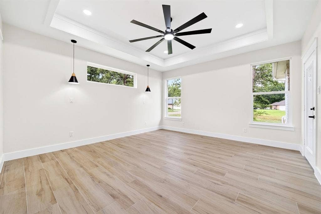 120 Springwood Road, Enchanted Oaks, TX 75156 Tray ceiling with recessed lighting, wood-finish flooring, and multiple windows