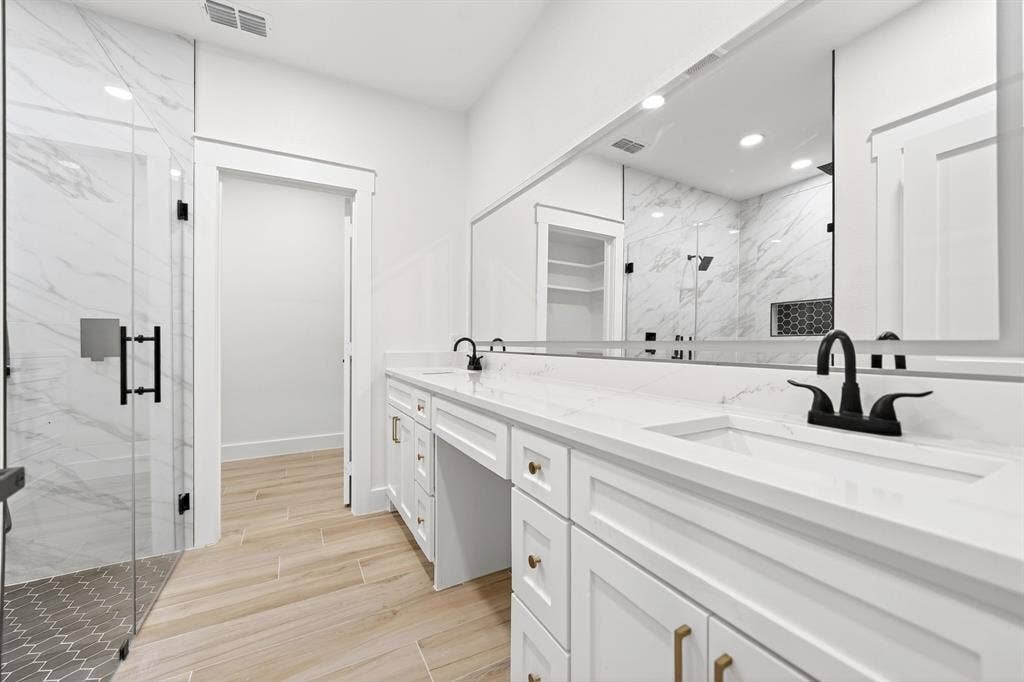 120 Springwood Road, Enchanted Oaks, TX 75156 White shaker cabinetry with gold-tone hardware, a dual vanity with undermount sinks, and a full-width mirror