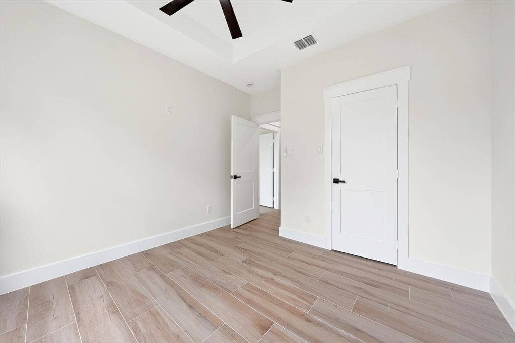 120 Springwood Road, Enchanted Oaks, TX 75156 Tray ceiling with a ceiling fan, wood-finish tile flooring, and white interior doors with dark hardware