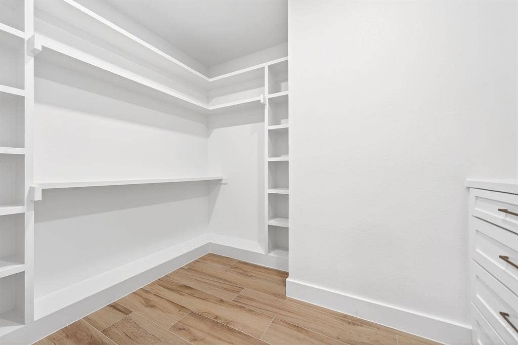 120 Springwood Road, Enchanted Oaks, TX 75156 Built-in closet shelving and storage, wood-finish flooring, and white cabinetry with drawer pulls