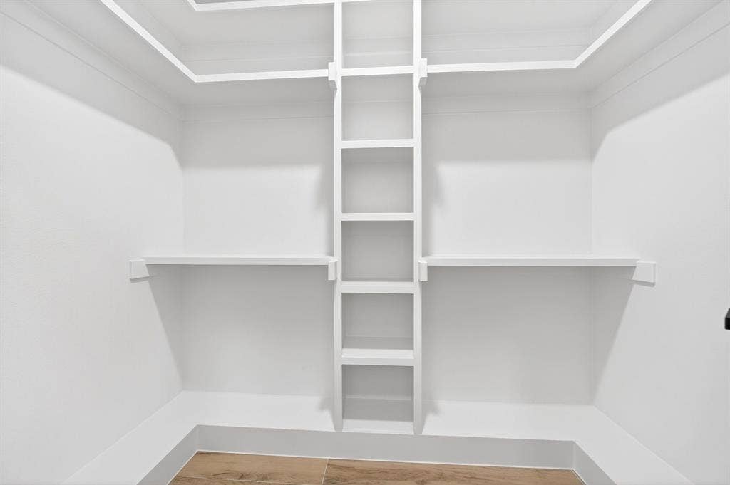 120 Springwood Road, Enchanted Oaks, TX 75156 White built-in shelving, white walls, and wood-finish flooring