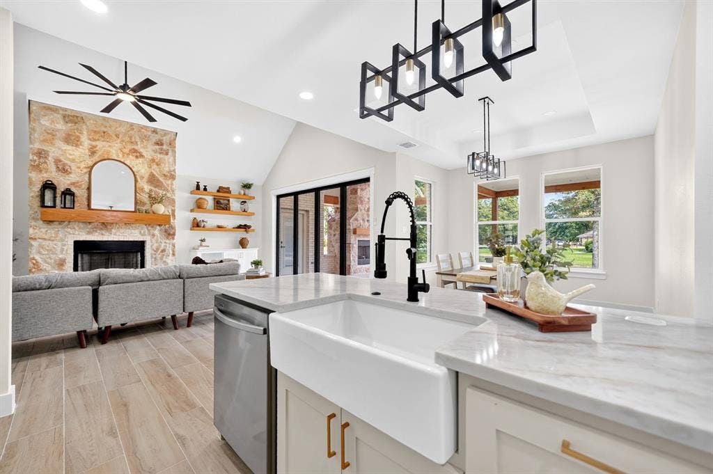 120 Springwood Road, Enchanted Oaks, TX 75156 Spacious kitchen island with a farmhouse sink, stainless steel dishwasher, and stone-finish countertops