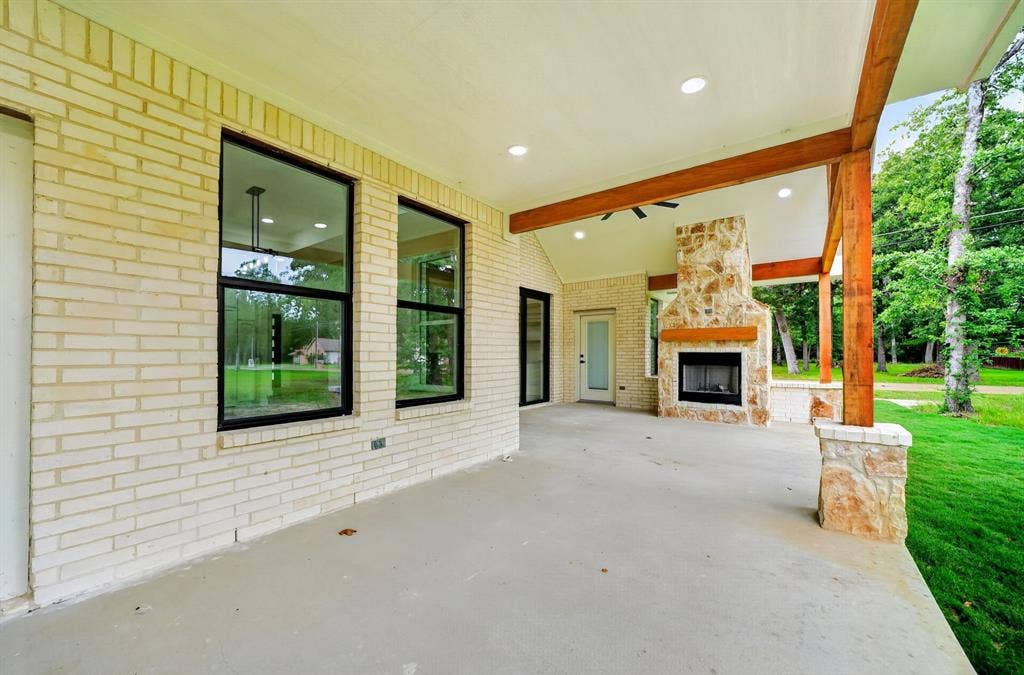 120 Springwood Road, Enchanted Oaks, TX 75156 Covered patio with a stone-clad fireplace and wood mantel