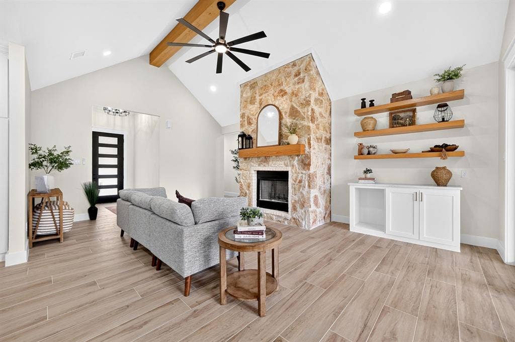120 Springwood Road, Enchanted Oaks, TX 75156 Vaulted ceiling with exposed wood beam, stone-surround fireplace with wood mantel, wood-finish flooring, built-in shelving, and recessed lighting