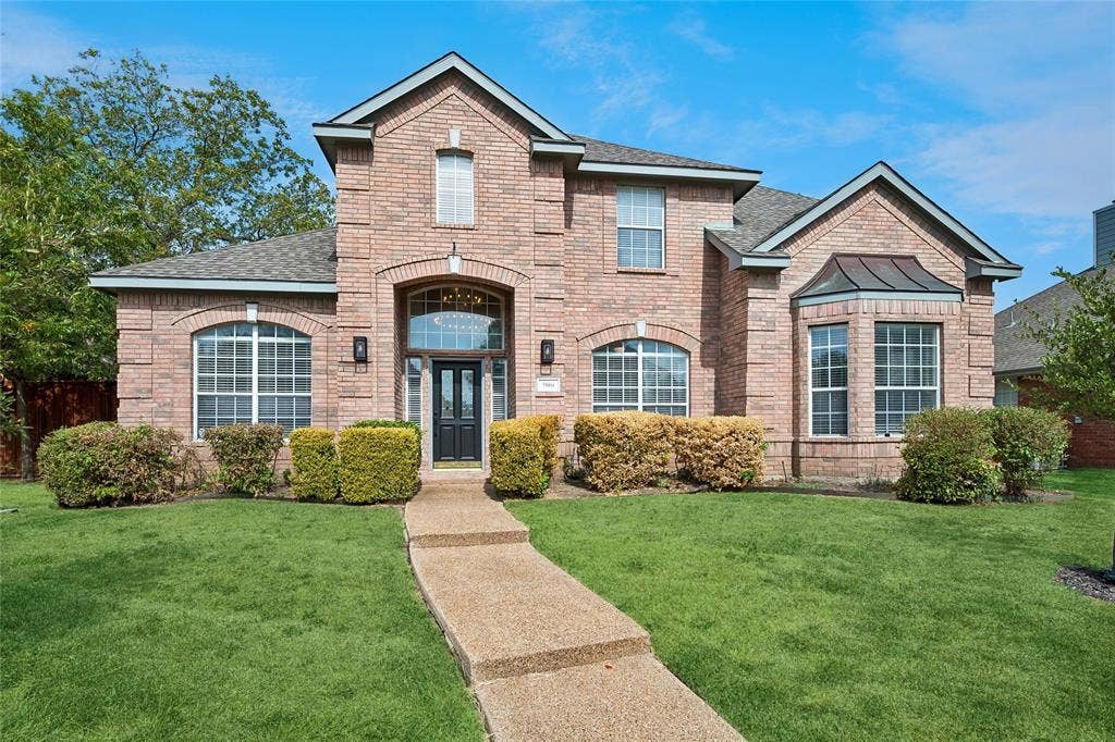 3801 Kite Meadow Drive, Plano, TX 75074 *ENHANCED GRASS PHOTOS**Brick exterior with arched entry, bay window, dark panel front door, and a concrete pathway