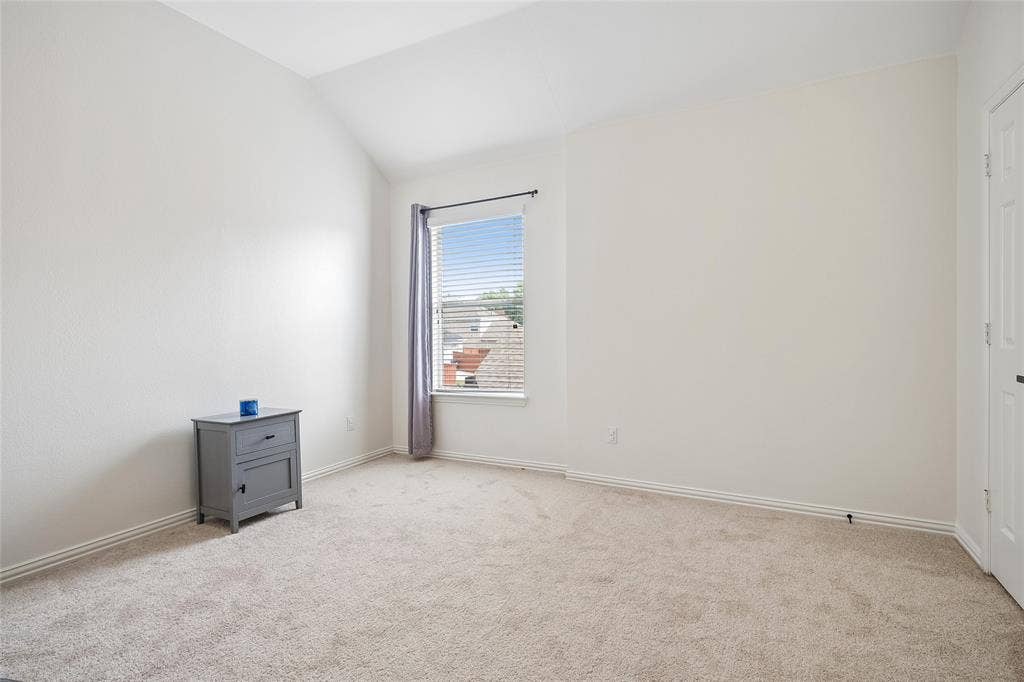 3801 Kite Meadow Drive, Plano, TX 75074 Vaulted ceiling with neutral paint, carpeted flooring, window with blinds, and white paneled door