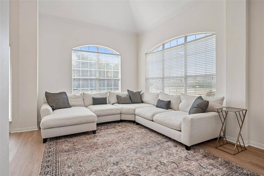 3801 Kite Meadow Drive, Plano, TX 75074 Vaulted ceiling, two large arched windows, light wood-finish flooring, and crown molding
