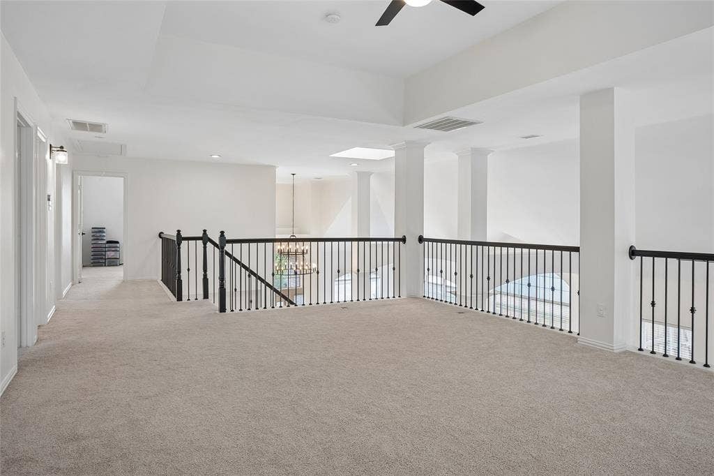 3801 Kite Meadow Drive, Plano, TX 75074 Expansive carpeted landing with a decorative iron railing, recessed lighting, and a ceiling fan