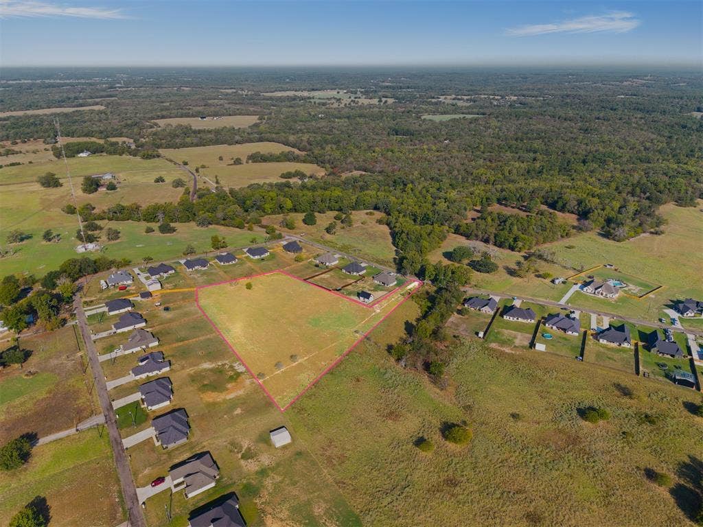 15610 County Road 436, Lindale, TX 75771 Expansive level lot with surrounding residential properties, bordered by established wooded areas