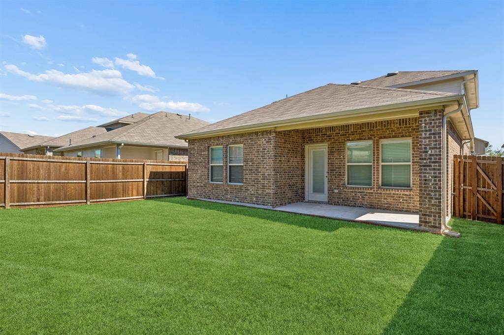 3719 Mildren Bend, Crandall, TX 75114 Expansive backyard with a wood privacy fence and a covered patio